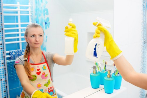 Trained cleaner using protective gloves and safe procedures